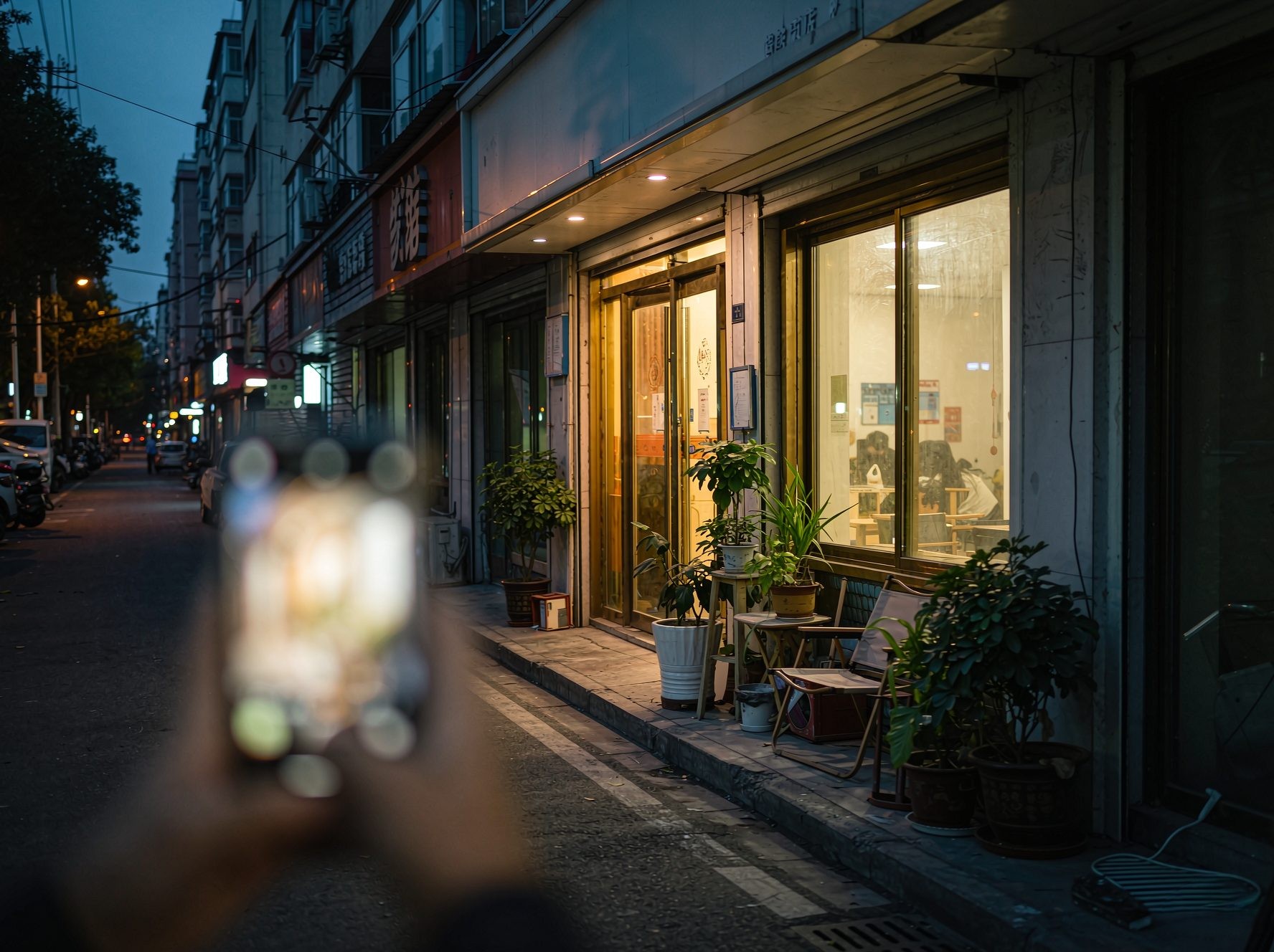 黄昏时分的城市街边小餐馆，暖光透出